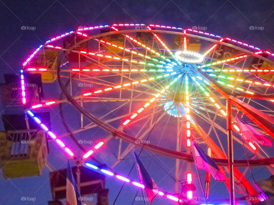 Neon Sky. An illuminated Ferris wheel at a local carnival makes for a colorful  and bright night sky