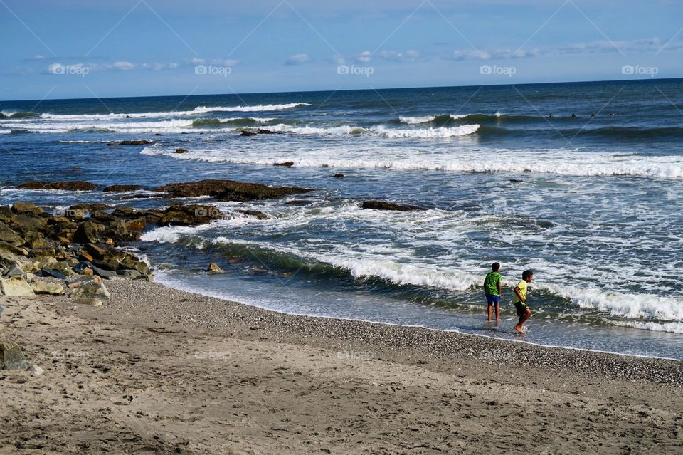 Beach with kids playing in  water 
