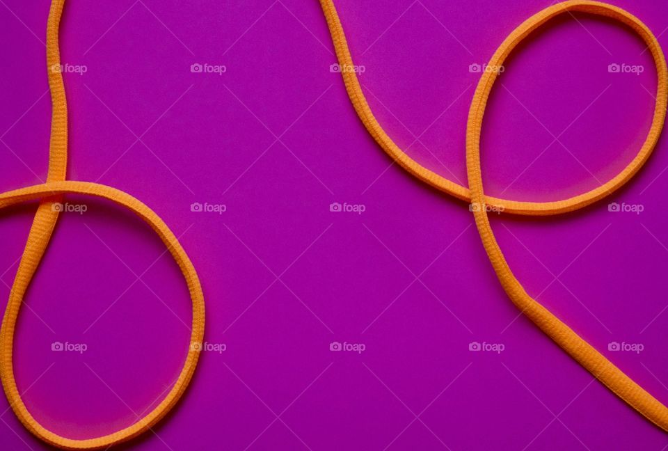 Neon orange nylon cord on a bright fuchsia background 