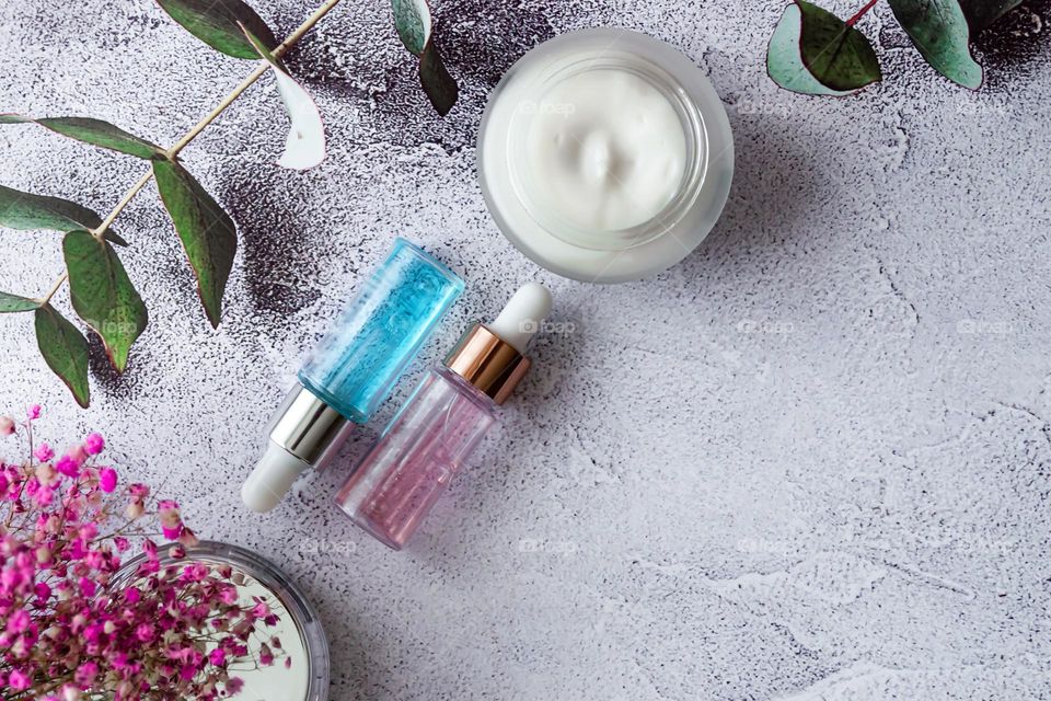cosmetics serum and moisturizing face cream on marble gray background