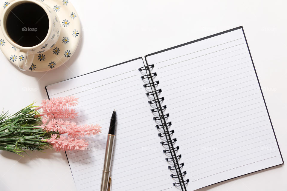 Flat lay of blank blank notebook with pen, flower and coffee on white background