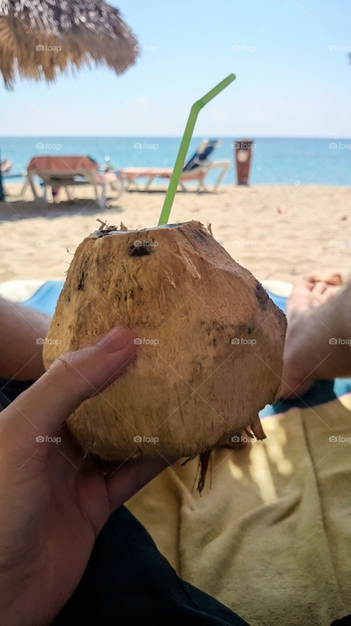 Coco Loco Caribbean. On a beach, enjoying the sunshine, and drinking a beverage from a coconut.