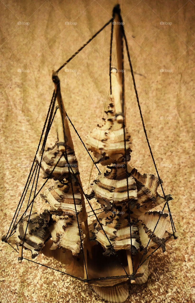 Ship made of seashells on a background of sand