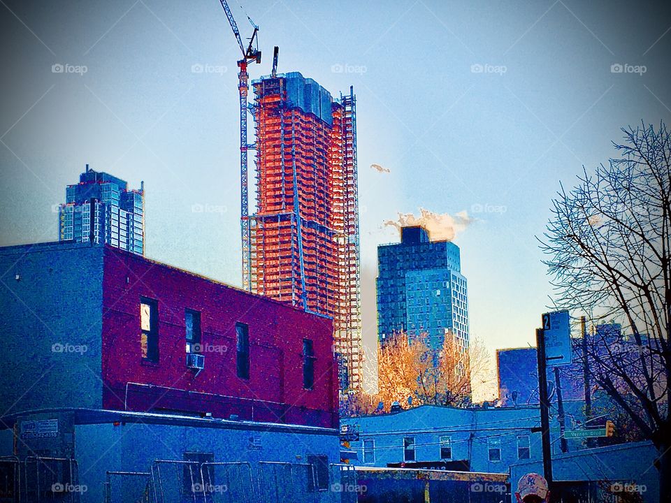 Long Island City, Queens, NY during the golden hour of dusk in 2018. The buildings illuminated by the setting sun gleam gold, orange to red and those in the shade are purple to blue, a portent of the approaching twilight. Hypnotic Productions