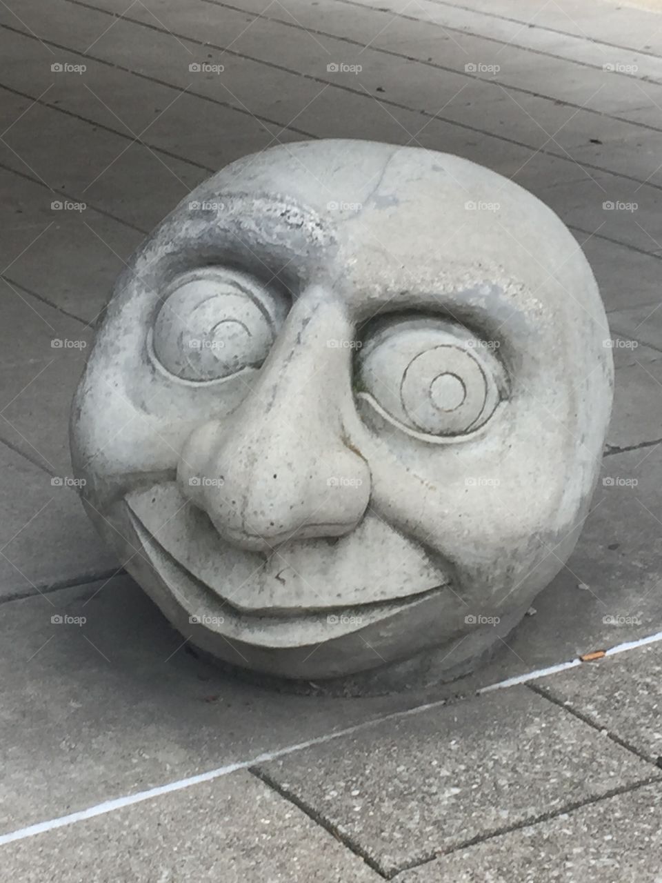 Gray Stone Head on the Empty Sidewalk in the Empty City of L’Ville