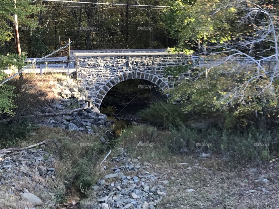 Old bridge while walker by down a trail 