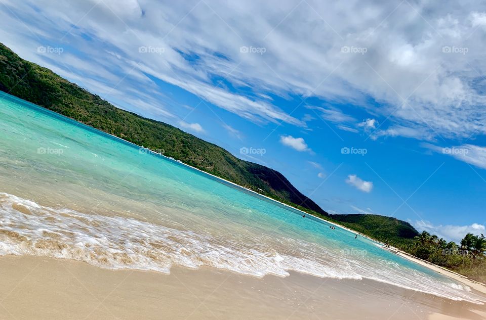 Lush green mountains rising from beautiful turquoise waters of The Caribbean 
