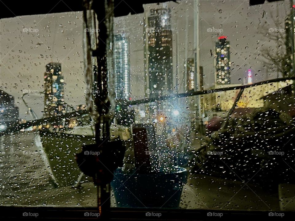 Like a glittery curtain draped over the nighttime image of NYC are these raindrops illuminated from behind on the window of “Salvation”, the “28 ft 1969 Luhrs” cabin cruiser at “Newtown Creek” in LIC that is our home. 2023. Hypnotic Productions