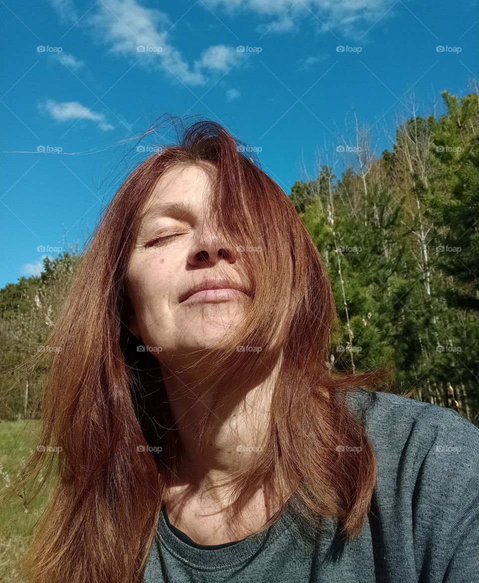 happy woman outside blue sky background