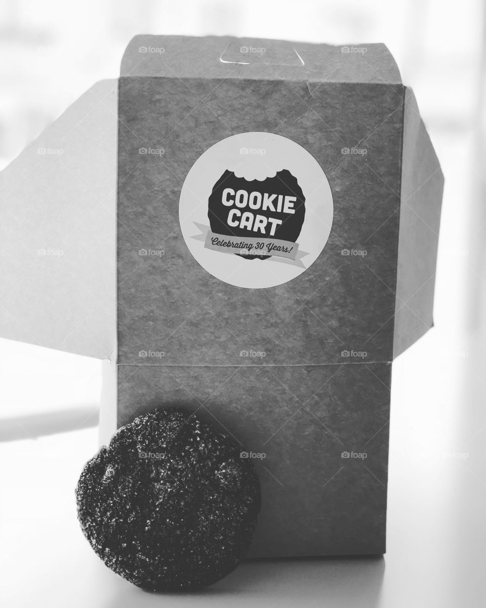 Black and white photo of Cookie Cart box and cookie. 