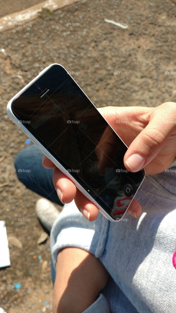 Celular na mão de garota.