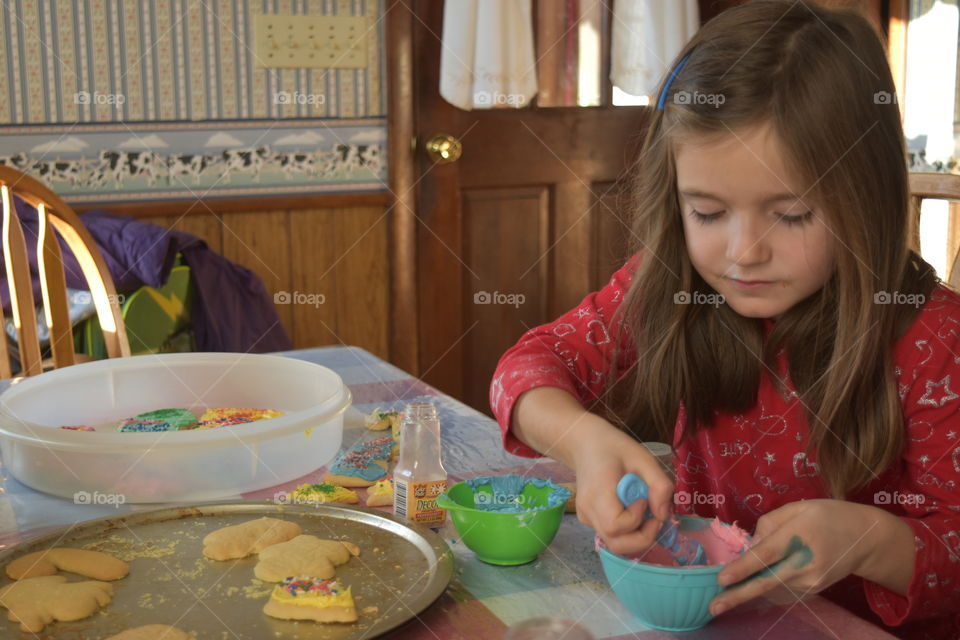 little girl frosting cookies