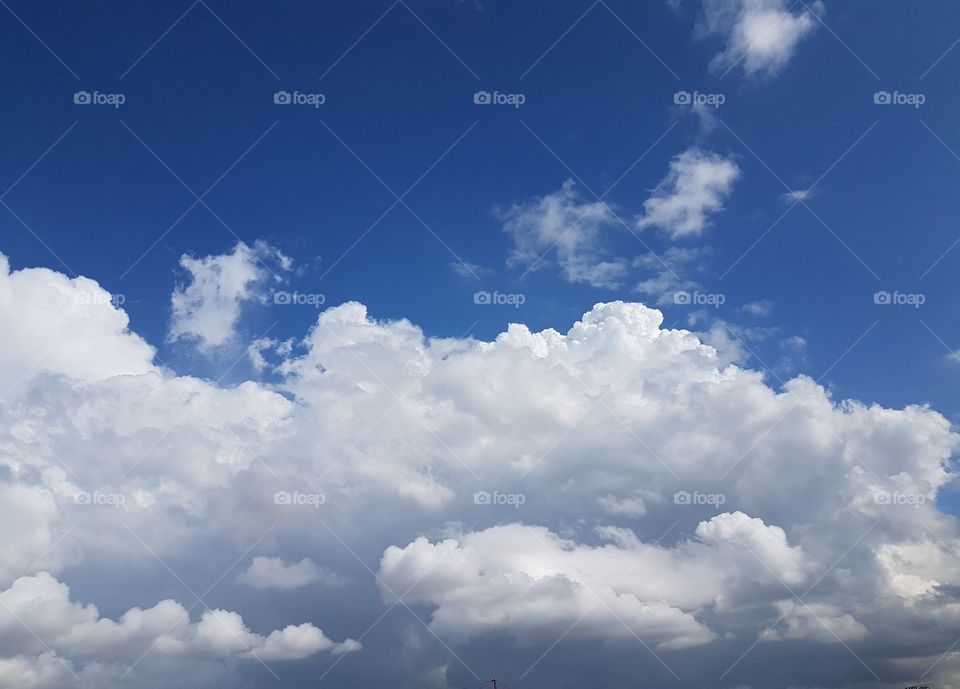 Full frame of huge white clouds forming  over  bue sky background
