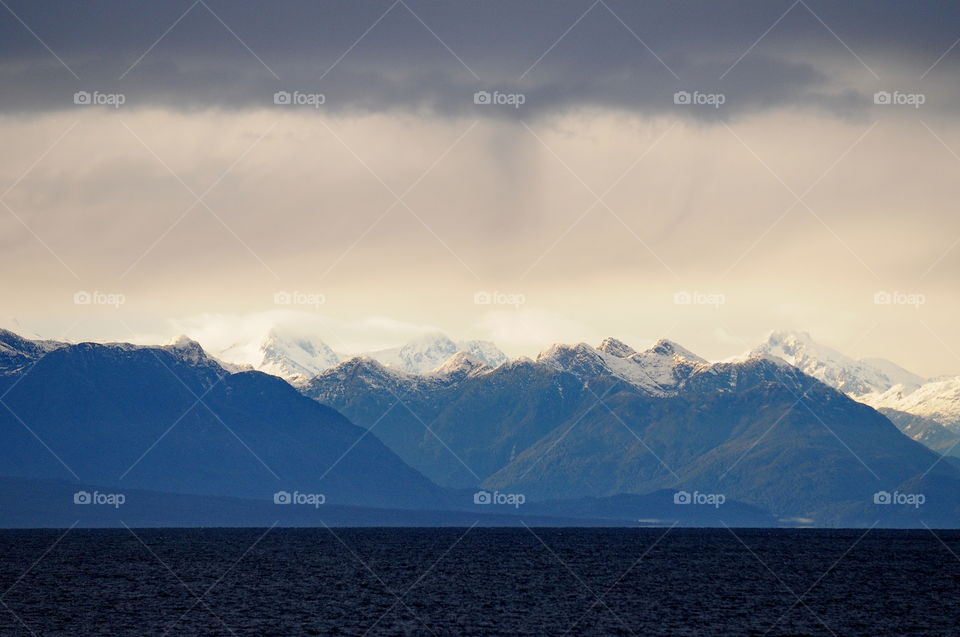 A view of the snow covered peaks of the Andes Mountains while sailing to Puerto Montt, Chile.