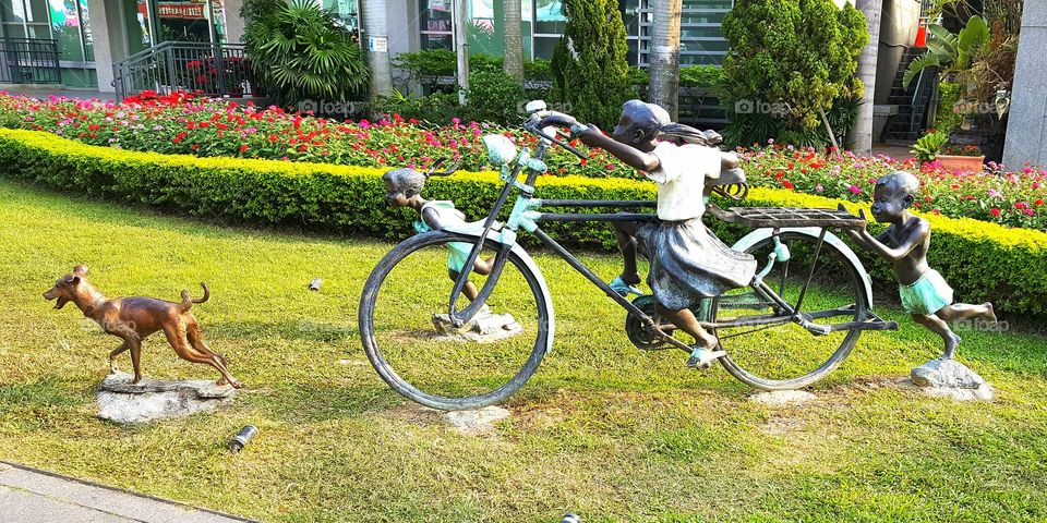 Child statue, bicycle statue and dog statue