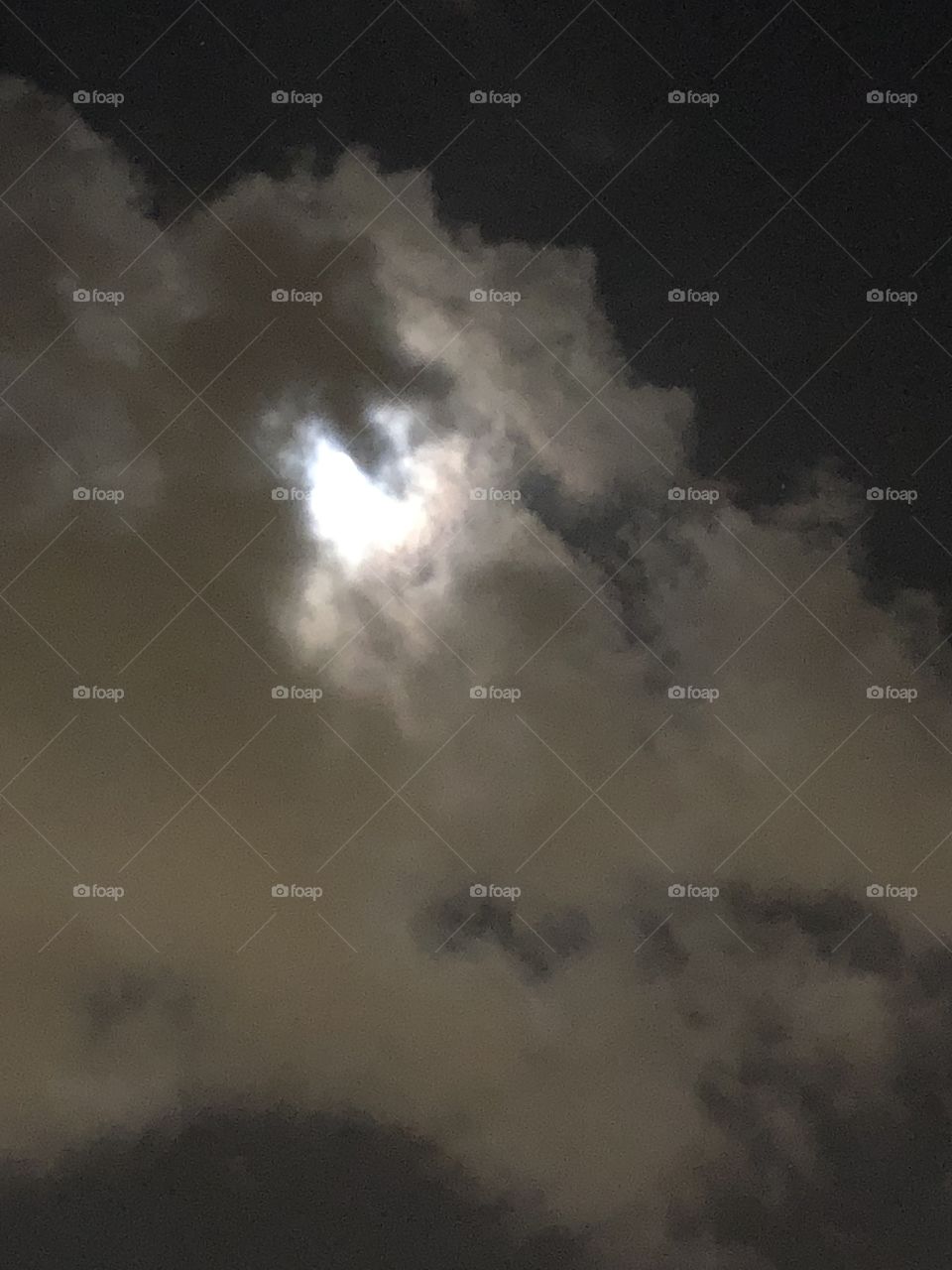 The moon behind the clouds