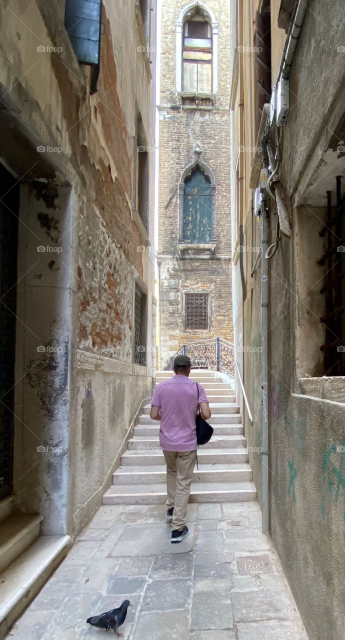 Man walking the streets of Venice Italy pondering the historical significance of the city