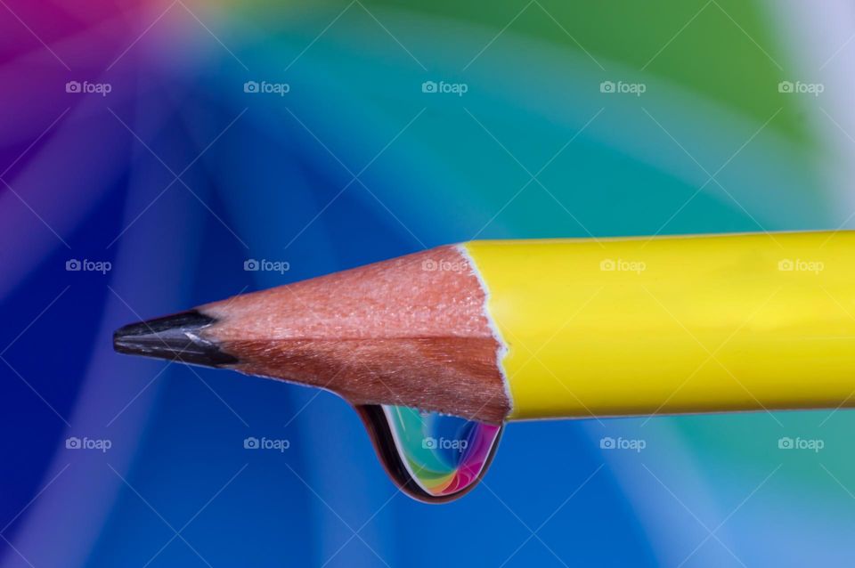 Macro view of color pencil alongwith water drop.