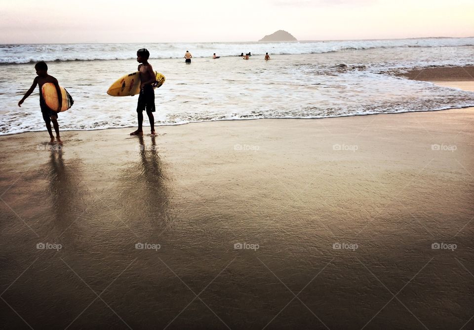 Kids with surfboards in a Brazilian beach