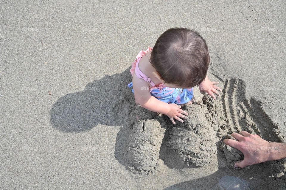 little girl with legs in the sand