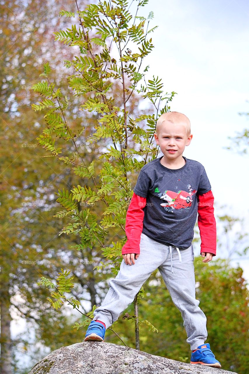 Cute boy on a rock