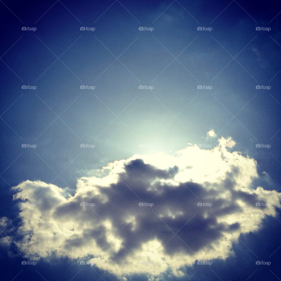 Sun hiding behind chubby cloud.