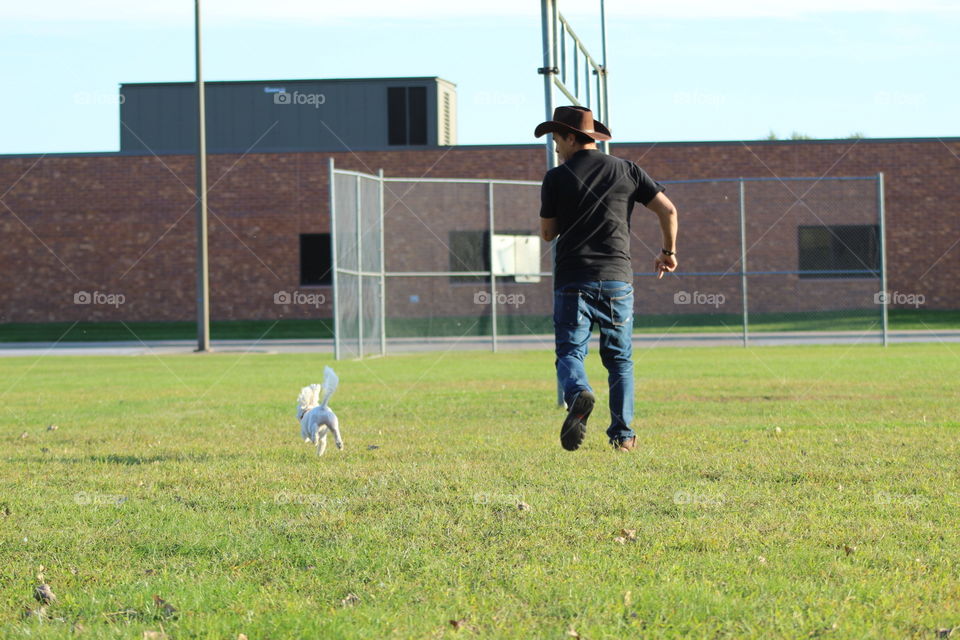 From A to B.-Man and his dog running through the park 