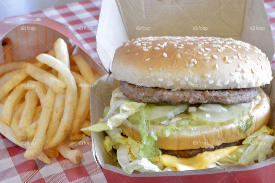 McDonald’s big Mac and a large fry on a red and white checkerboard back ground