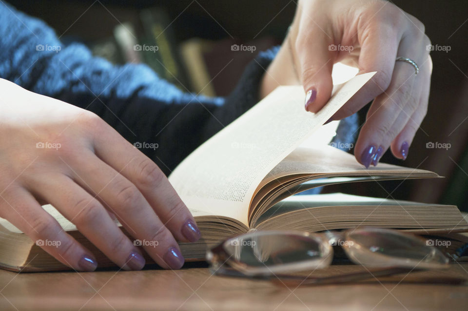 The girl reads the book, turning the pages