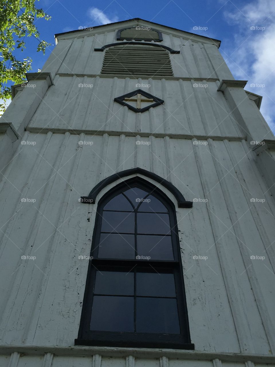Looking upward at the front of an old wooden church that's active only 10 weeks a year.  Volunteer pastors lead non-denominational, Christian services.