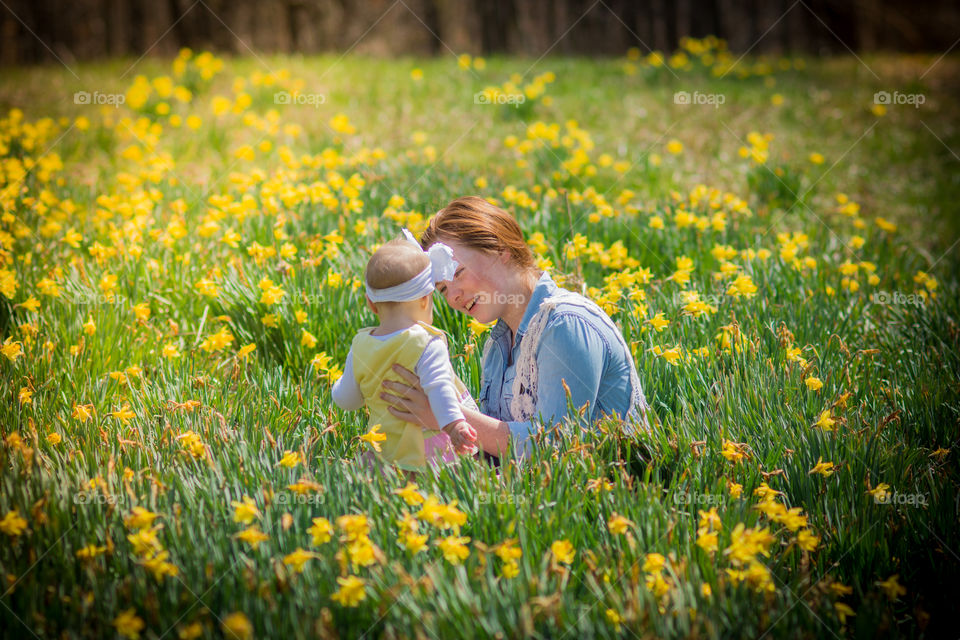 Mother with her daughter in daffodil field