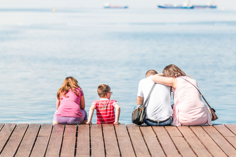 Family Enjoying The View Sitting On The Dock
