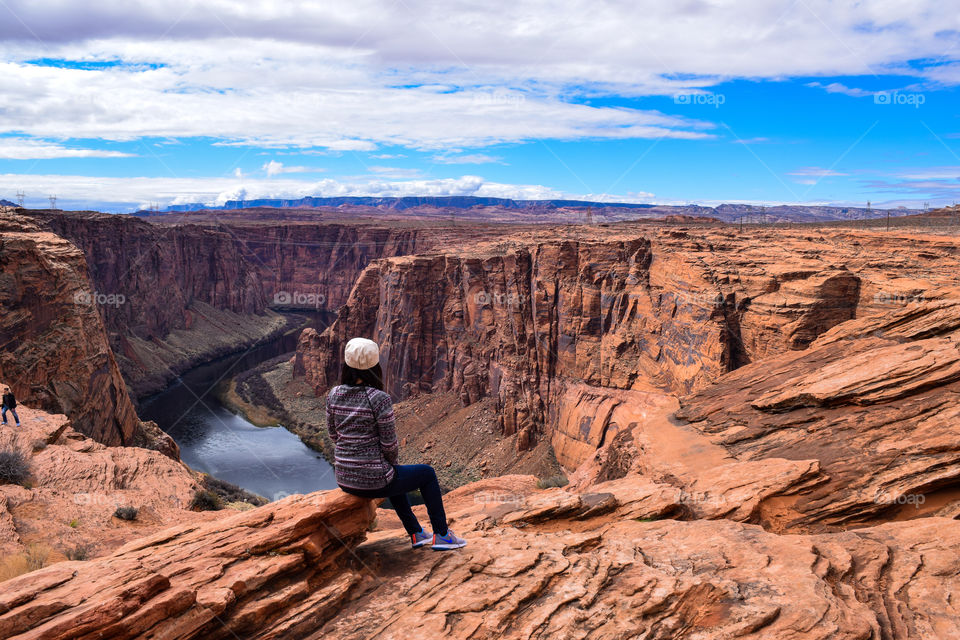 A woman sitting by the rocks of Glenn canyon 