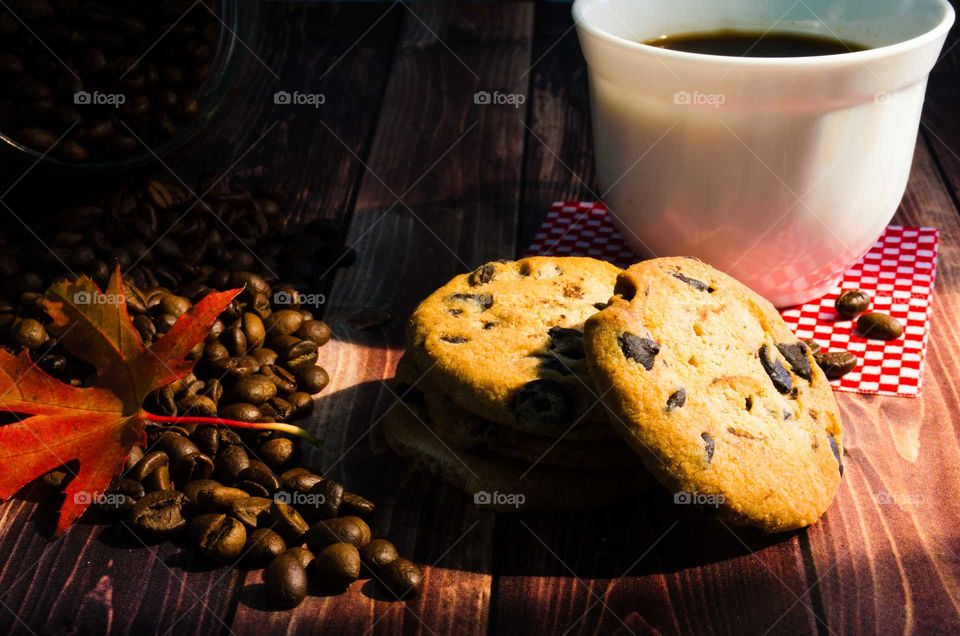 Cup of coffee and cookies on wood