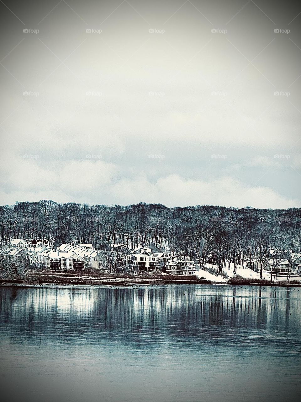 Snowy village reflected off water