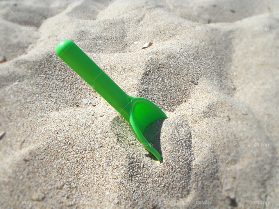 Plastic spoon in sandy beach