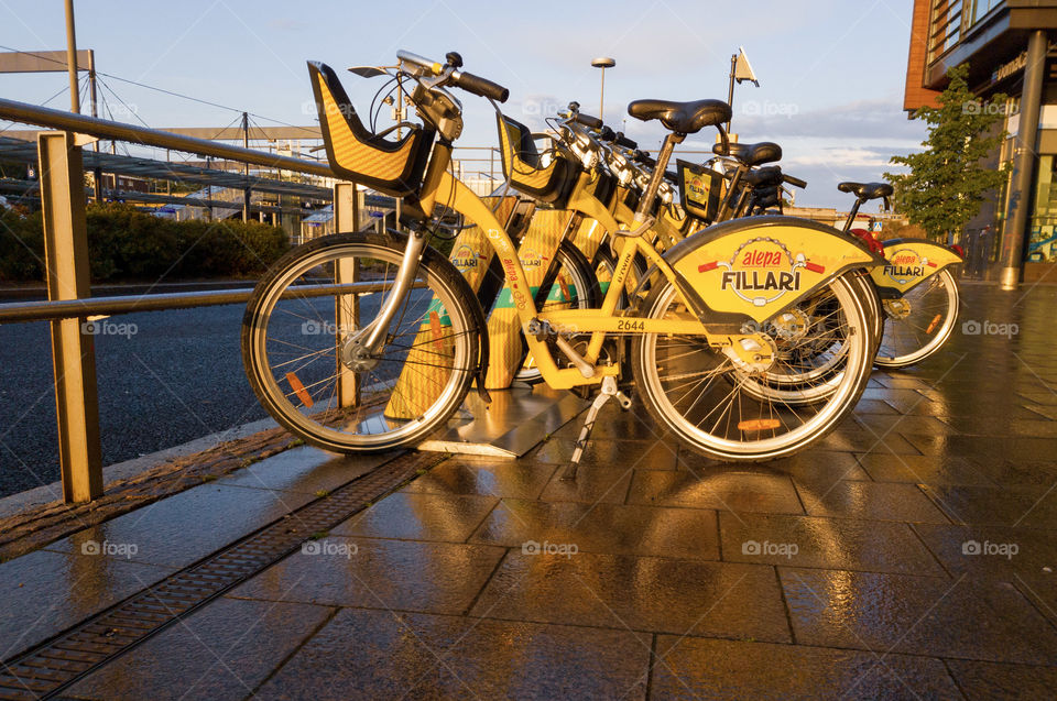 Espoo, Finland - August 9, 2019: Yellow city bikes parked at sidewalk by the Sello shopping mall in Leppävaara district of Espoo. City bikes are alternative means of public transportation in Helsinki metropolitan area.