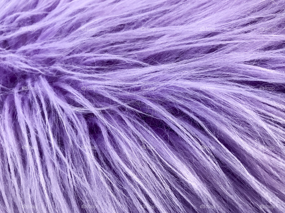 A plush texture of purple faux fur pillow