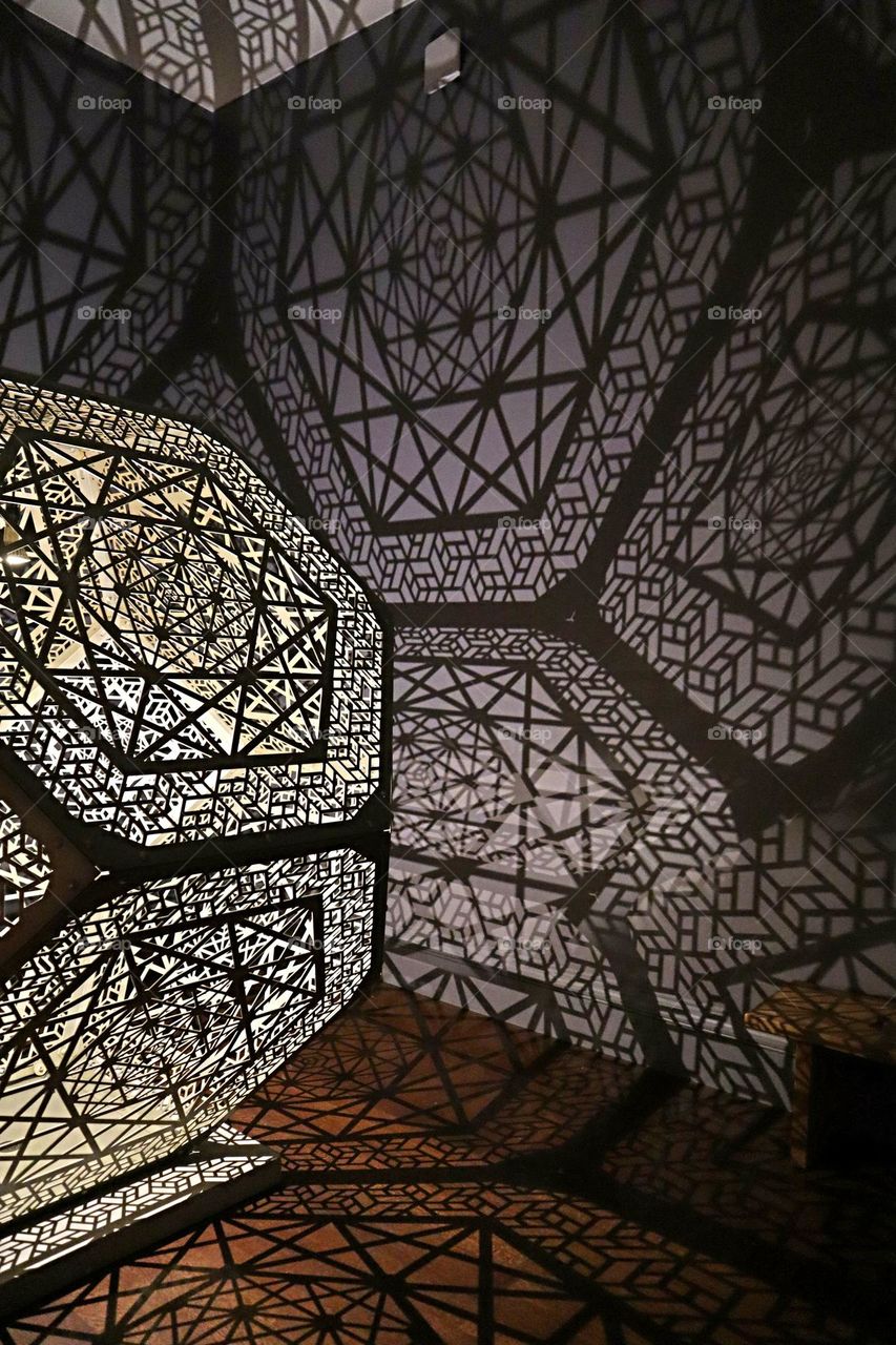 reflections shining through a light fixture with triangles and polygons as an art piece