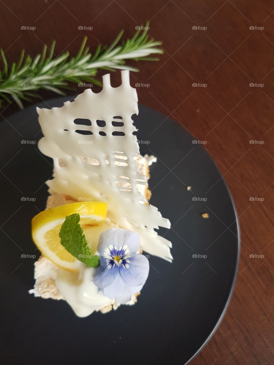 Resturant Desert Lemon Meringue Cake with white chocolate and edible flower