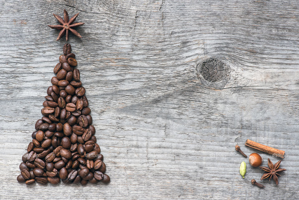 Christmas greeting card made of coffee beans on old wooden background