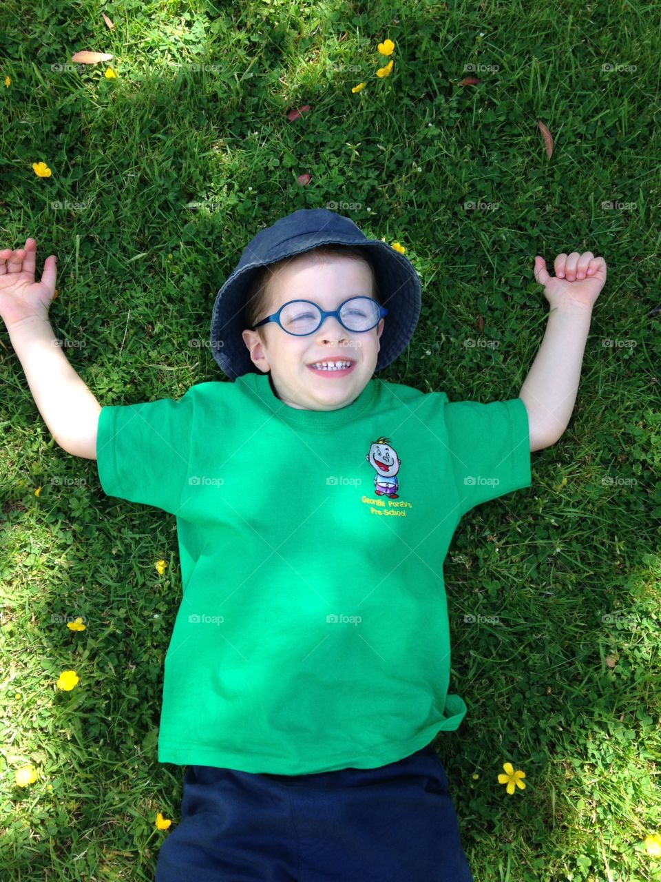 Boy in a Field. Happy boy in glasses laying in a grassy field