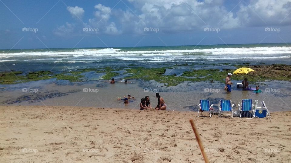 mom and daughters playing in the sand on the beach