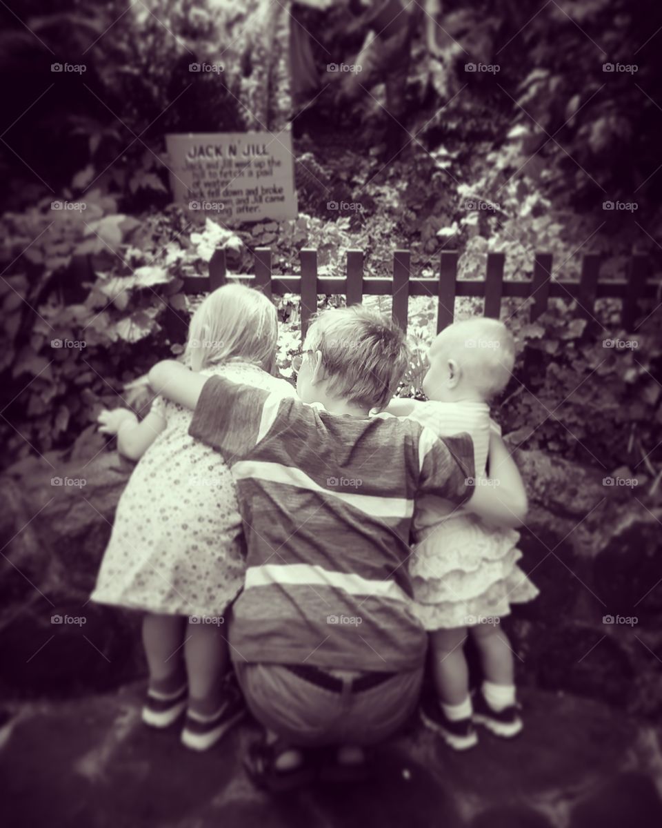 Rear view of brother and sisters in park