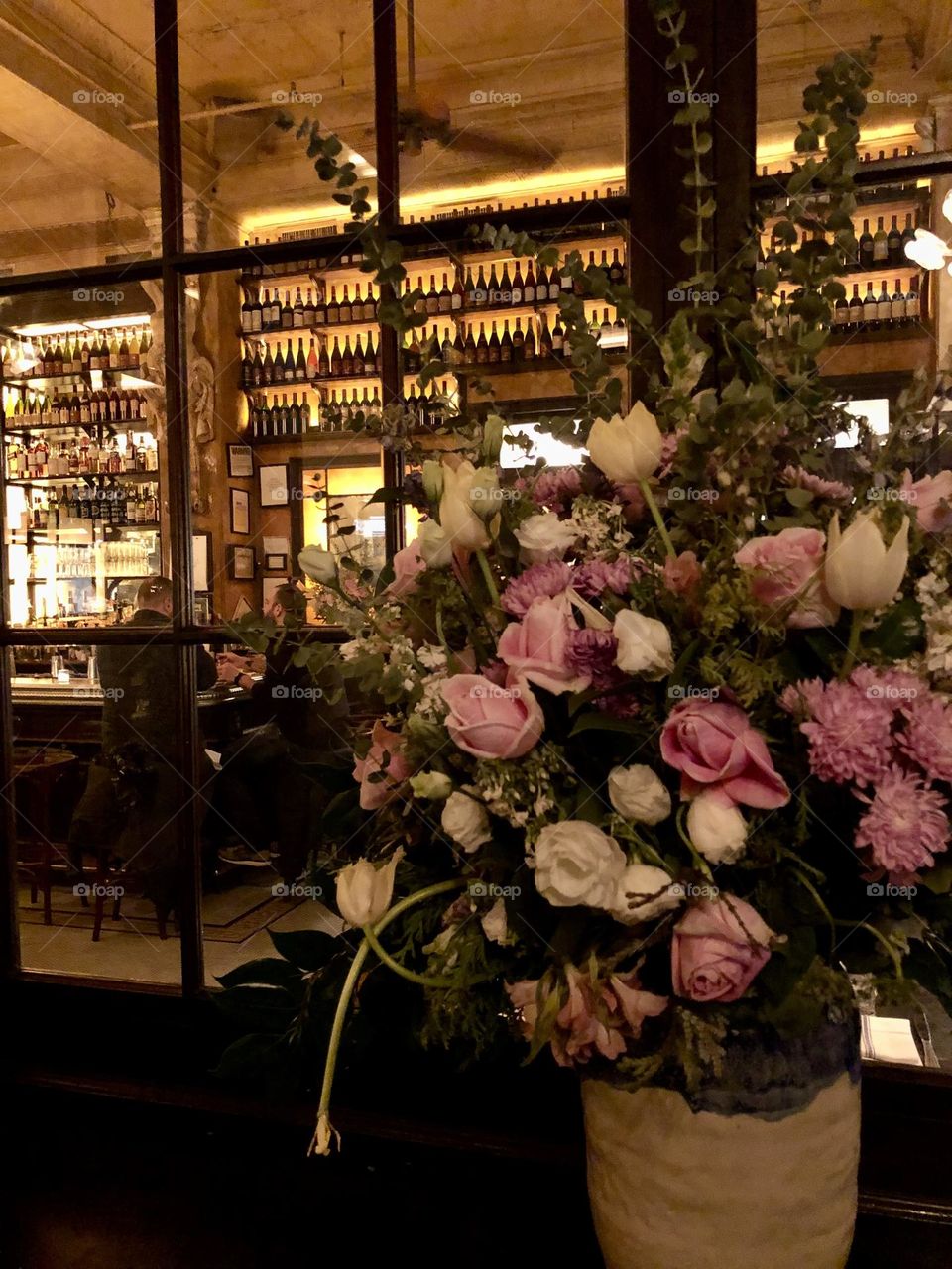 Bouquet of white and pink flowers in a vase at the entrance of a restaurant 