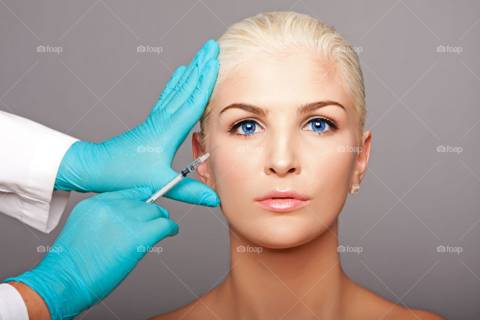 Portrait of a young woman getting cosmetic injection