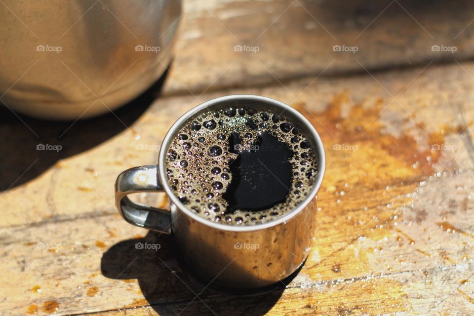 Mug with coffee on rustic wooden table