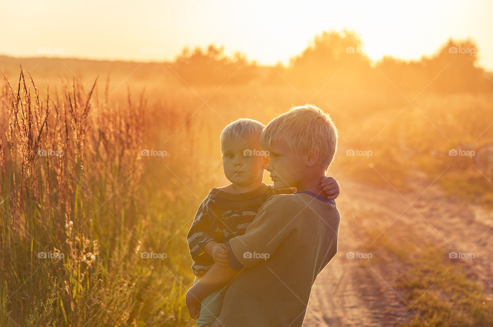 Two brothers are walking in the summer countryside