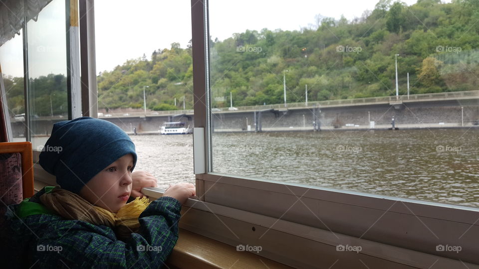 Girl looking out through boat's window