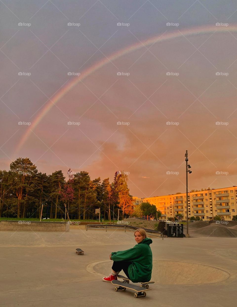 Girl in a skatepark under the rainbow. 